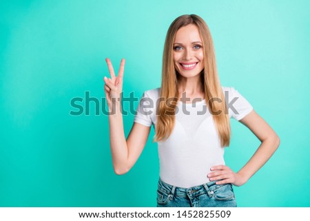 Portrait of nice sweet girl smiling making v-signs isolated over teal turquoise background