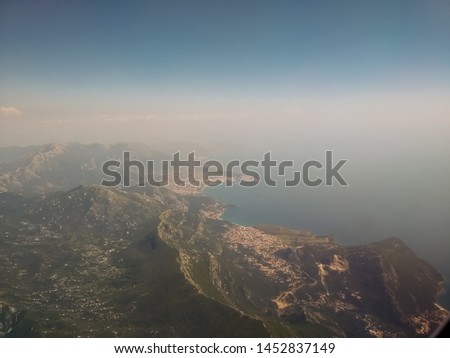 View from the airplane to the sky above the Montenegro mountains. Blue sky with clouds. Background. stock photo