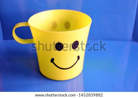 Yellow cup with a smile on a blue background
