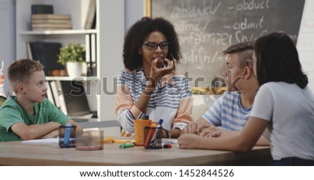 Medium shot of speech therapist explaining to pupils in a classroom Royalty-Free Stock Photo #1452844526