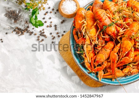 Boiled crayfish on a plate side view on a concrete background.
