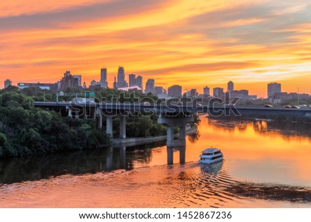 A Dramatic Golden Sunset Sky over Minneapolis and Riverboat Traffic under the Dartmouth Bridge