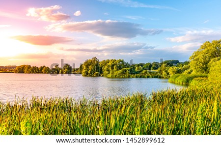 Evening sunset at calm pond and lush greenery of south bohemian landscape, Czech Republic.