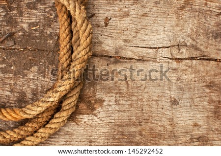Ship rope and weathered wood background, top view