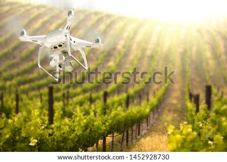 Unmanned Aircraft System (UAV) Quadcopter Drone In The Air Over Grape Vineyard Farm. Royalty-Free Stock Photo #1452928730