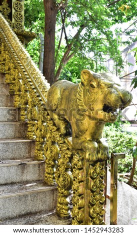 Close-up of Golden Tiger statue on the head of the stairs to the temple at Bangkok, Thailand.