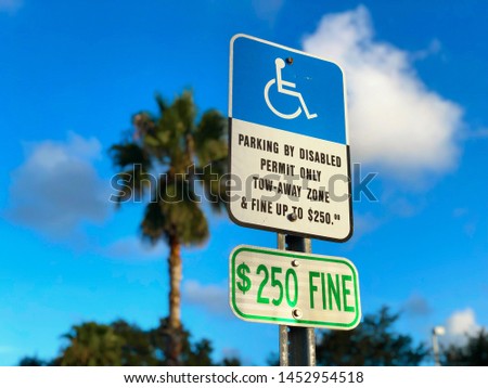 Disabled Parking Permit Sign ($250 Fine) on Blue Sky in Miami, Florida.