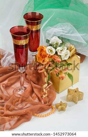 Glasses with wine on a decorative fabric background