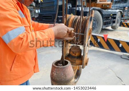 Crane operator conducting safety inspecting on the wire sling which attached with crane lifting hook prior completed his daily work construction site Royalty-Free Stock Photo #1453023446