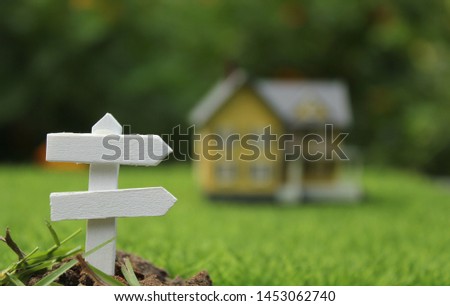Rustic Signboard in Rural  Outdoor Area, Blurred Farmhouse in background 
