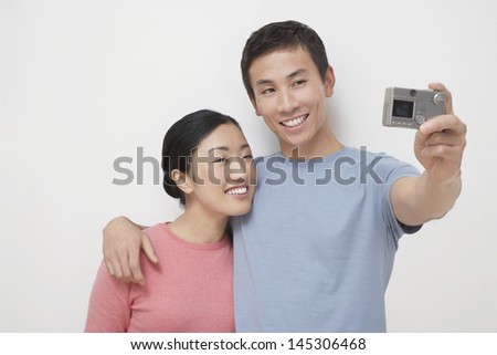 Young man with girlfriend taking picture of themselves