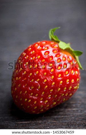 Ripe and juicy strawberries on the dark rustic background. Selective focus. Shallow depth of field.