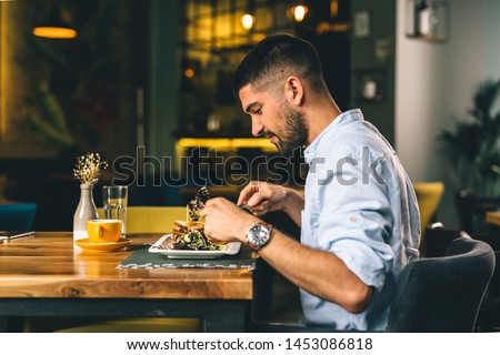 man having breakfast or dinner in cafe Royalty-Free Stock Photo #1453086818