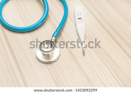 Blue stethoscopes on wood table for medical content.