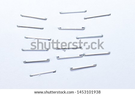 Front side staples pushed into a piece of white paper. Isolated on white background. Royalty-Free Stock Photo #1453101938