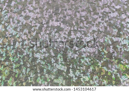 Silvery holographic fabric with folds. Abstract geometric background or texture.