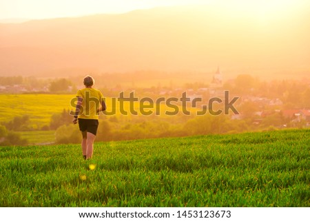 Runner in yellow sunset evening light. Sport photo, beautiful nature