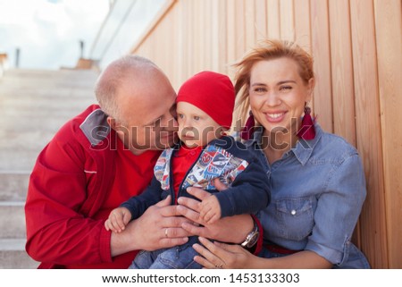 Happy family with a small child on a walk in a summer park. Rest in the city, outdoor