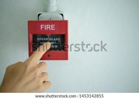 Human hands are pulling fire alarms on the walls, Hand is pushing fire alarm switch,The concept of a picture about fire alarms in buildings.