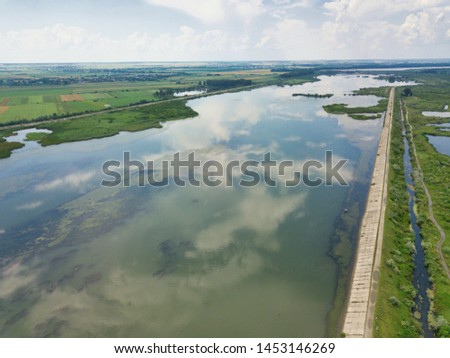 Aerial view of blue river whit reflections on a sunny summer day. Drone photography. River Olt, Romania.
