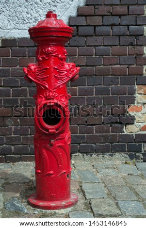 ornate old fire hydrant against the brick wall
