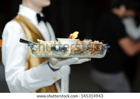 waiter serving meat and perogies in restaurant