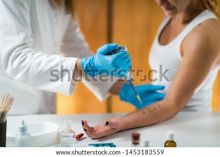 Immunologist Testing Allergy Reaction on a Woman’s Arm Royalty-Free Stock Photo #1453183559