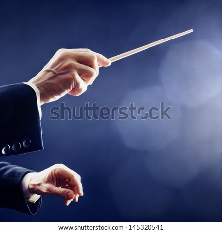 Orchestra conductor hands baton. Music conducting director holding stick Royalty-Free Stock Photo #145320541