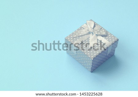 Small blue gift box lie on texture background of fashion pastel blue color paper