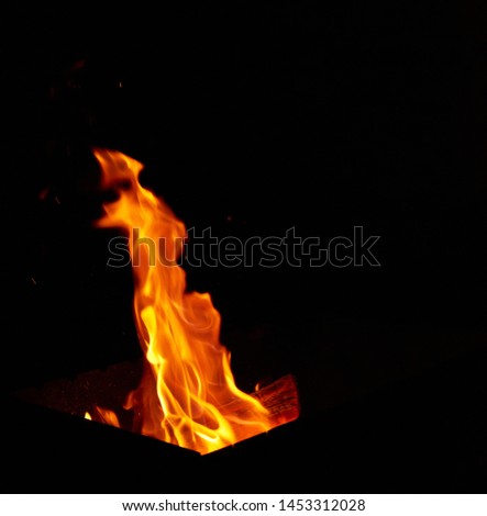 bright orange and yellow flames with sparks, close up, black background 