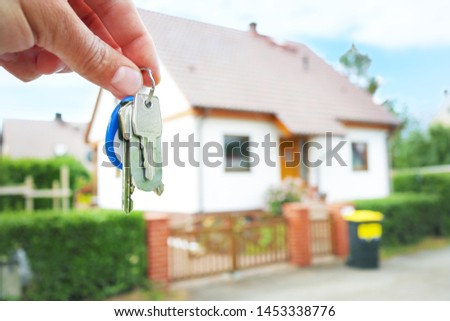 Keys in hand against the background of a blurred house
