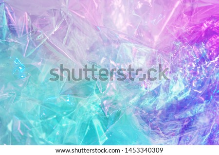 Holographic background in the style of the 80-90s. Real texture of cellophane film in bright acid colors. Royalty-Free Stock Photo #1453340309