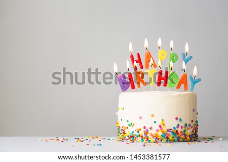 Birthday cake with colorful candles spelling happy birthday