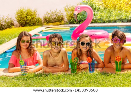 Happy friends with beverages on outdoor pool party