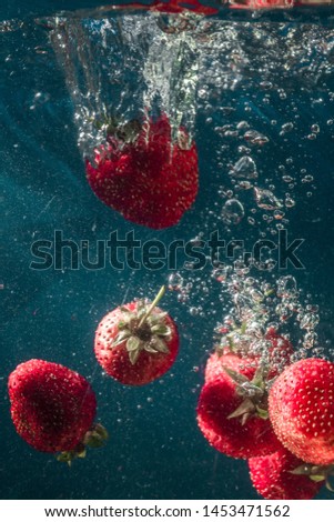 Juicy strawberry flavor. A spray of water. Freshness of summer. Fruits. Fruit freshness. Berries. abstraction. Still-life. Strawberries are like an explosion of taste. Strawberries in water. 