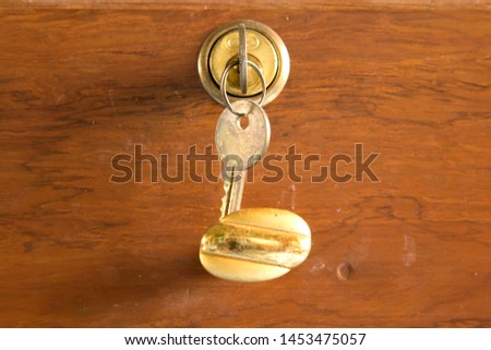Keys for locks and old golden teak drawers protect your belongings and valuables from theft - beautiful classic home furnishings. Royalty-Free Stock Photo #1453475057