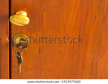 Keys for locks and old golden teak drawers protect your belongings and valuables from theft - beautiful classic home furnishings. Royalty-Free Stock Photo #1453475060