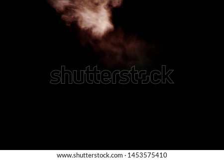 Stop the movement of multicolored powder on dark background. Abstract colored powder on black background.