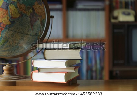 Close-up many books stacked on the table in the library Orb is the background selective focus and shallow depth of field