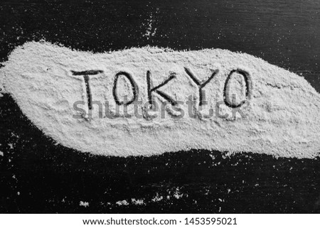 the word Tokyo is written in salt on a black board