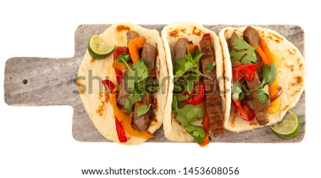 Three Fajitas on a Marble Serving Board Isolated on a White Background