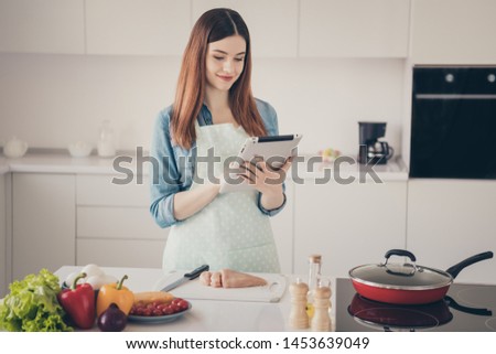 Photo of attractive wife make supper looking e-reader website masterclass excited to start preparation