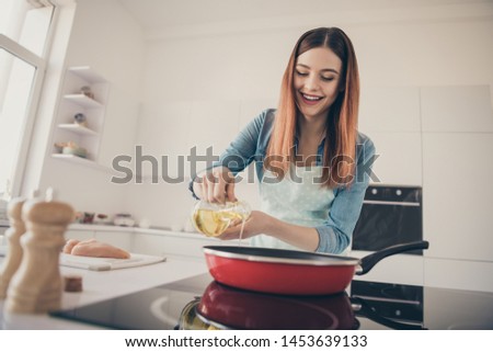 Photo of funny cheerful wife wear dotted apron presenting new brend olive oil best addition diet dishes