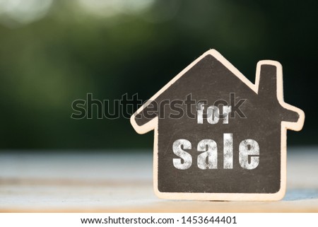 For Sale - written on the little house shape tag - real estate concept Royalty-Free Stock Photo #1453644401