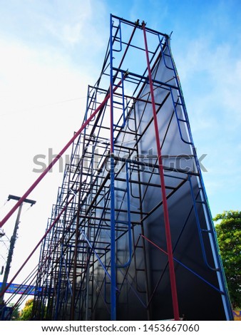 Metal structures that are the structure of billboards, steel structures of temporary advertising signs and bracing for strength On a blue sky background with white clouds.