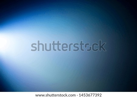 blue light beam projector in dark black room , smoke abstract background .