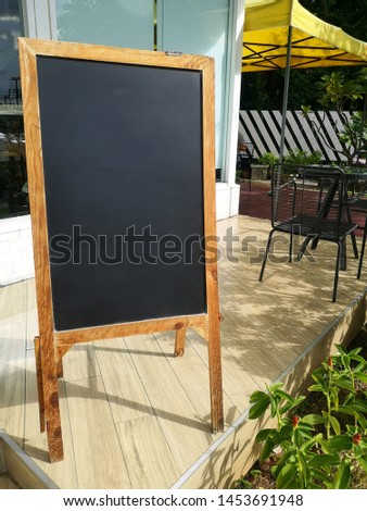 blank wooden menu board stand in front of coffee shop