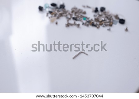Hex key in the center and pile of screws and bolts in the background