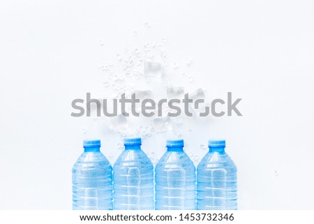 Plastic bottles with pure water and ice on white background top view space for text
