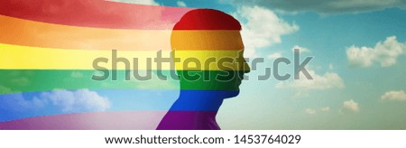 Silhouette of a man on the background of clouds and flag lgbt. Original conceptual idea on the subject of gender differences. Gay pride, LGBT, bisexual, homosexual concept. 